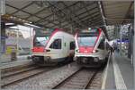 In Lausanne stehen zwei SBB Flirts RABe 523 und zeigen kleine, interessante Unterschiede: W�hrend der SBB RABe 523 026 sich in der traditionellen Farbgebung zeigt, ziert den SBB RABe 523 017 eine neuen Lackierung, welche durch das SBB Zeichen und die ...